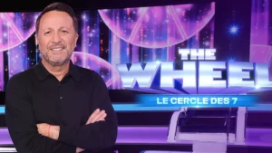 The Wheel, le cercle des 7 logo with host Jacques Essebag known as Arthur